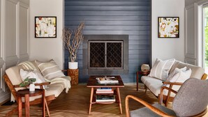 A living room with a fireplace, two sofas, a coffee table, and a chair.