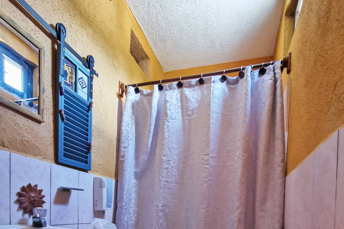 A bathroom with a sink, toilet, and shower curtain.