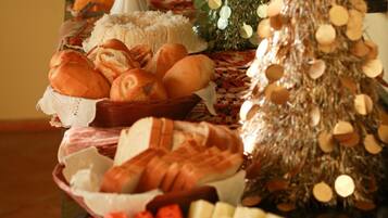 A buffet table with various food items and a decorated Christmas tree.