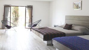 A hotel room with two beds, a balcony with curtains, and a chair. - Quinta Huizache (Nopaltepec)