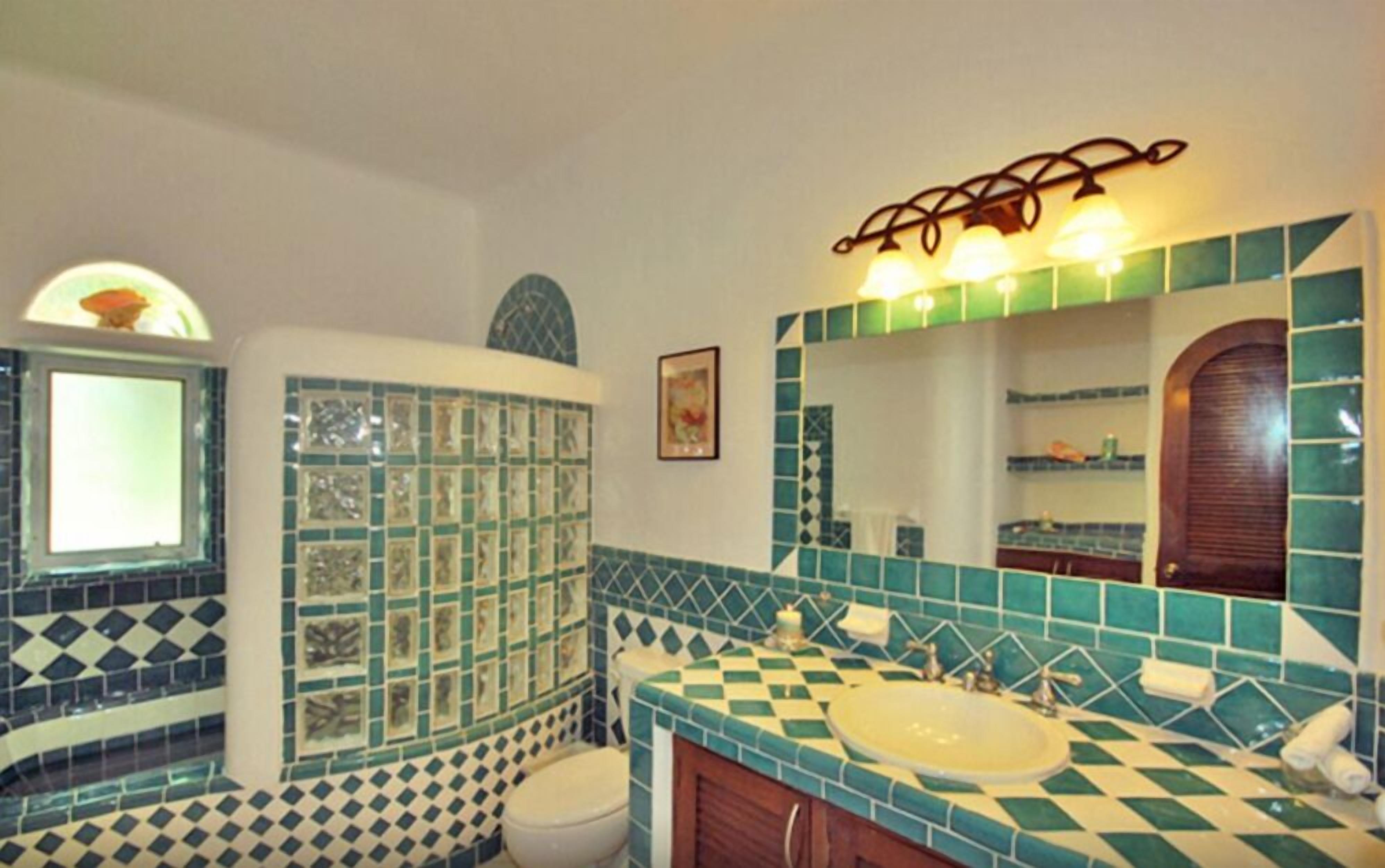 A bathroom with a checkered tile design, a sink, and a mirror.