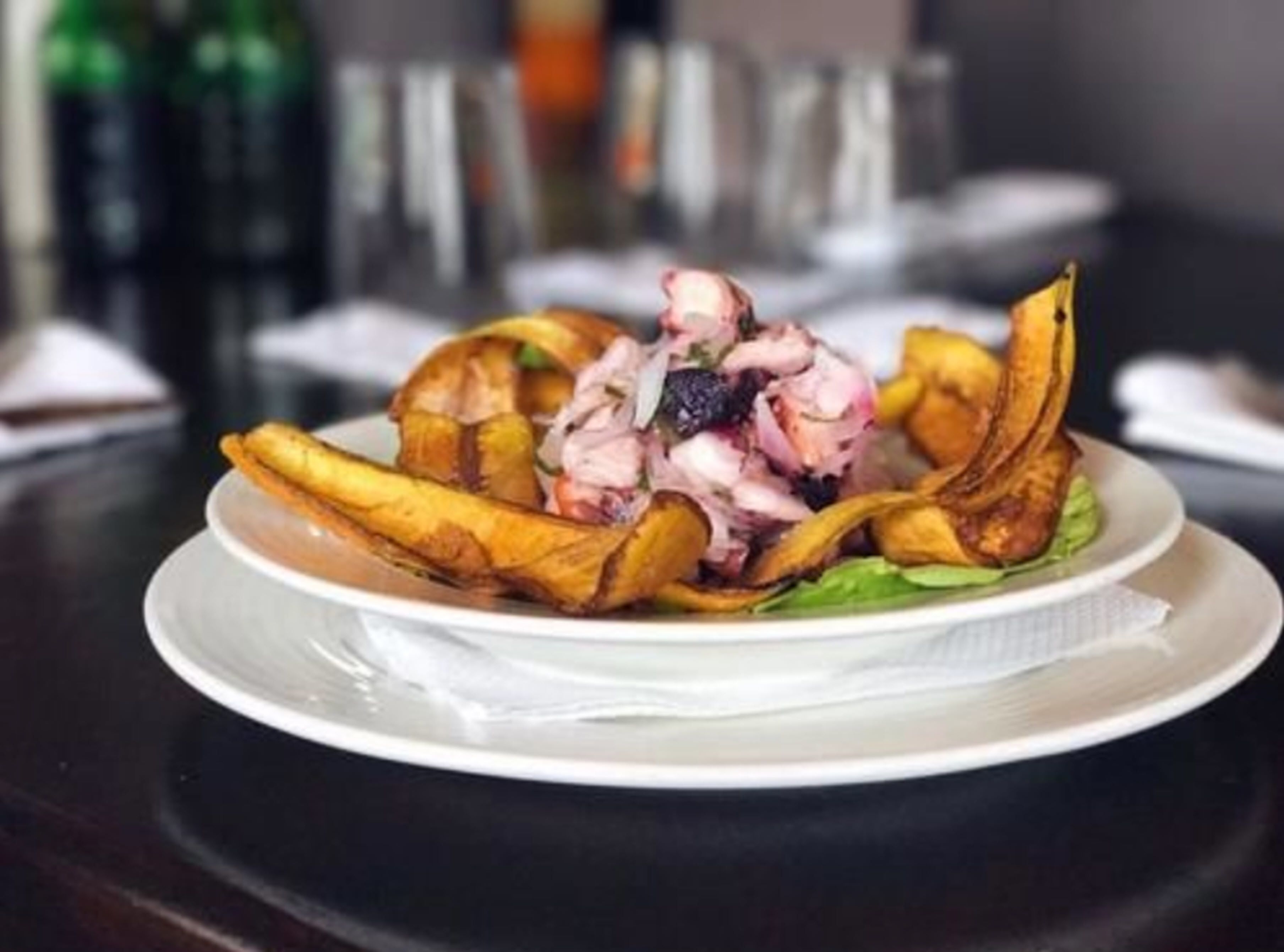 A plate of food with a salad and fried plantains on a white plate.