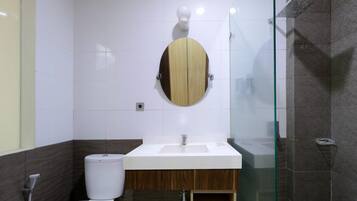 A bathroom with a toilet, a sink, and a shower area.
