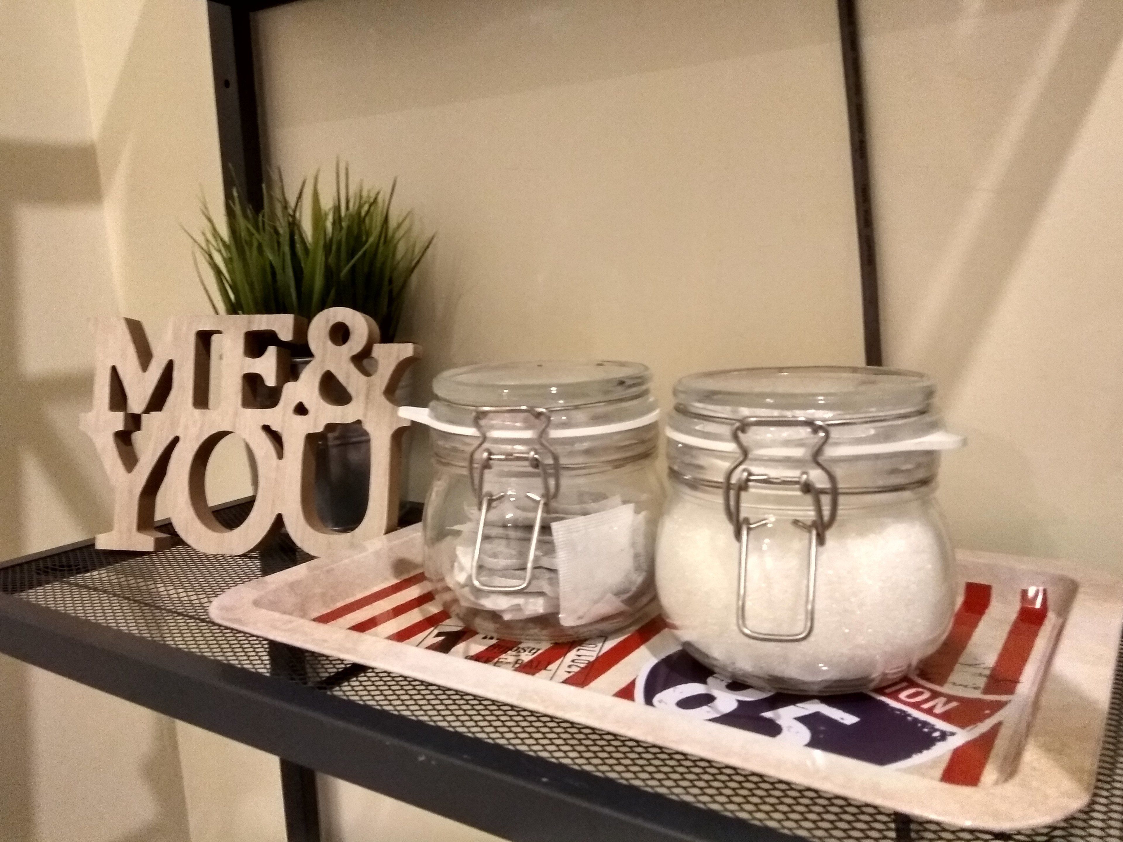 Two glass jars with metal clasps on a tray with a red and white striped cloth.