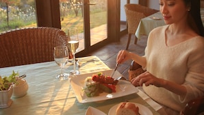 Una mesa de comedor con un plato de comida, un vaso de agua y una copa de vino.