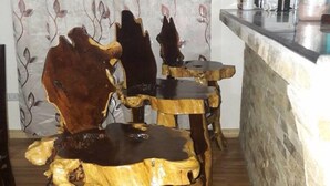 Un coin cuisine doté d’un comptoir en pierre et de deux tabourets en bois dont les assises sont recouvertes de peau d’animal.