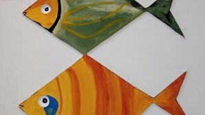 Two fish-shaped paintings on a white wall. - Millennium Inn (Hengchun)