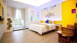A hotel room with a bed, a small table, a chair, a nightstand, and a window with curtains. - Millennium Inn (Hengchun)