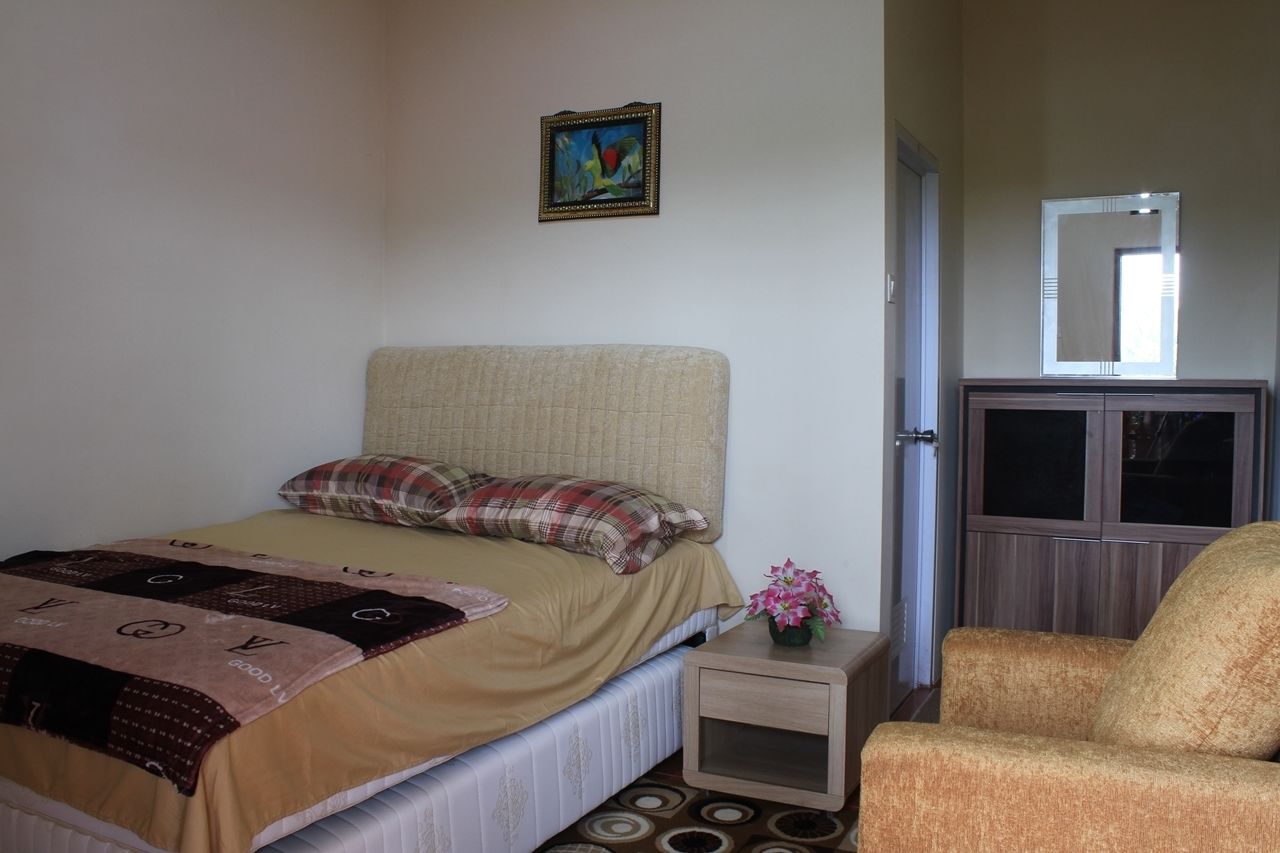 A bedroom with a bed, a nightstand, a chair, a mirror, and a painting on the wall.