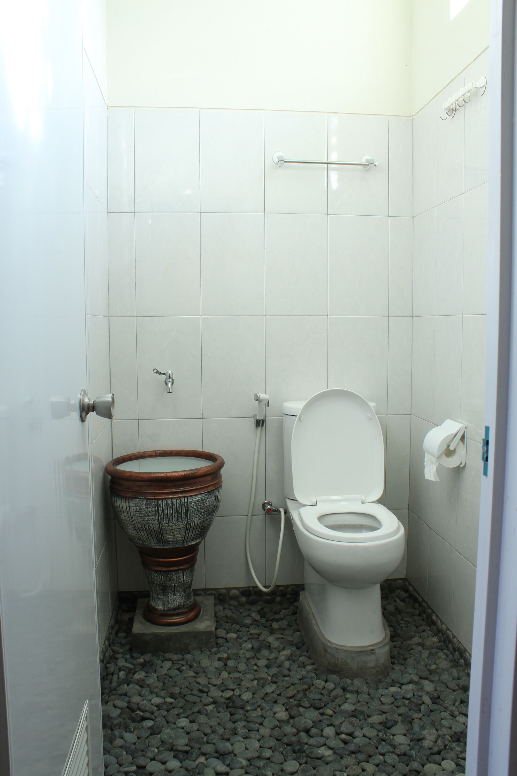 Une salle de bain équipée de toilettes, d’un bidet et d’un lavabo.