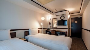A hotel room with two beds, a desk with a chair, a desk lamp, a clock, and a television on the wall. - Toyoko Inn Incheon Bupyeong (Incheon)