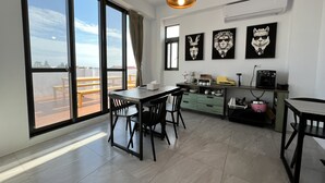 Una cocina moderna con zona de comedor, ventanas amplias y obras de arte en las paredes.