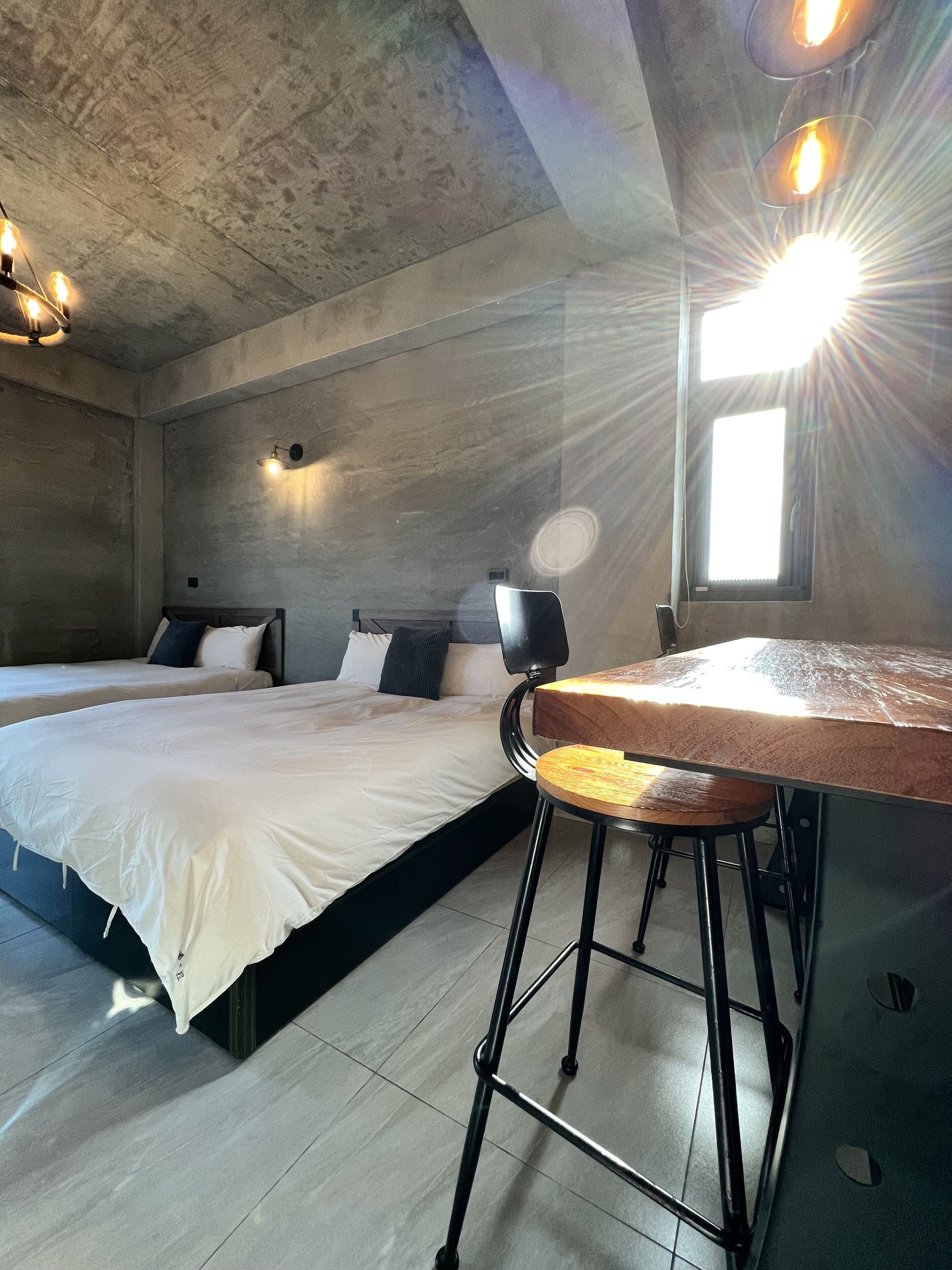 Une chambre moderne avec un grand lit, une petite table et une fenêtre.