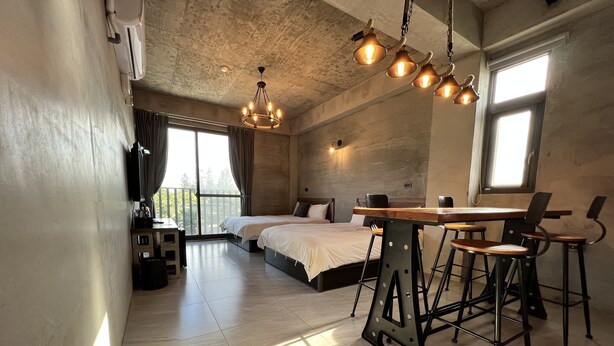 Un dormitorio moderno con una cama grande, un escritorio con sillas y una araña.