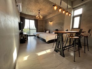 Un dormitorio moderno con una cama grande, un escritorio con sillas y una araña.