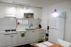 Eine Küche mit weißen Schränken, einem Herd, einer Spüle und einem Kühlschrank.