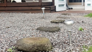 A gravel path with rocks and garden lights. - Sunny Namwon (Seogwipo)