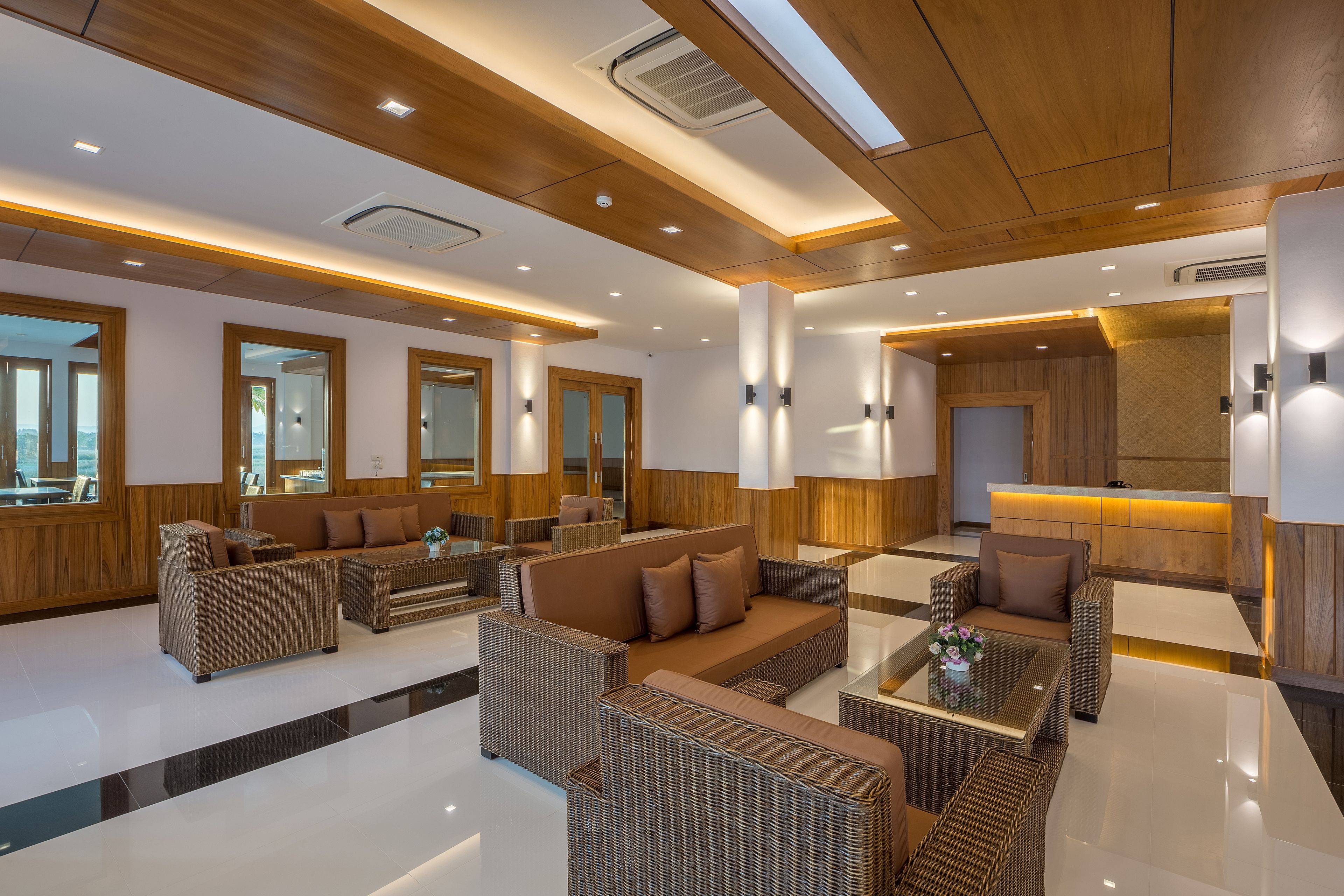 A modern lounge area with wicker furniture, a central sofa, and a glass coffee table.