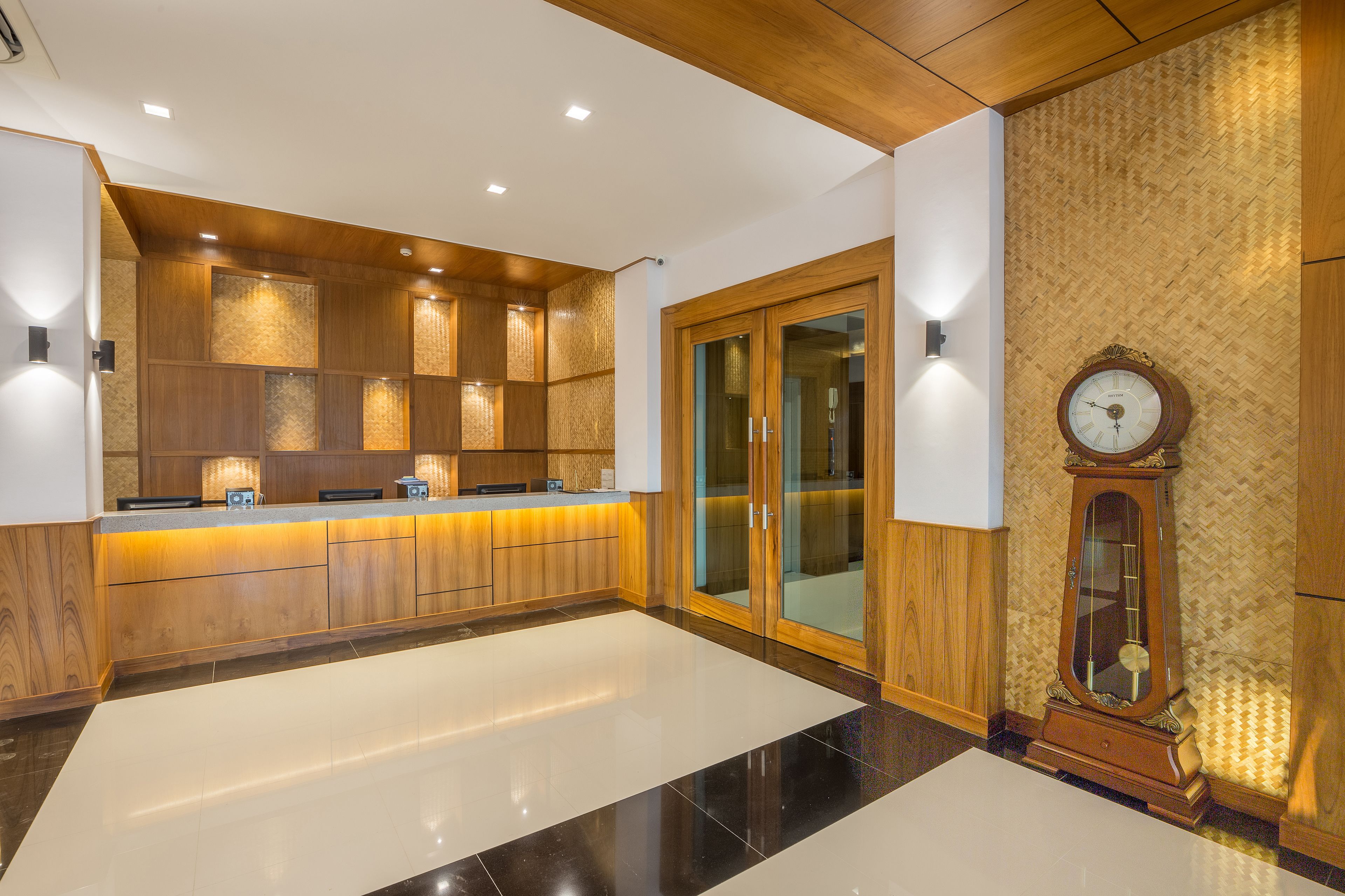 A modern kitchen with wooden cabinetry, a central island, and a built-in oven.