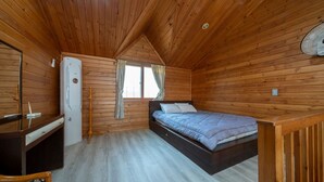 A wooden cabin room with a bed, a desk, and a window. - Jeju Bada Walking Pension (Seogwipo)