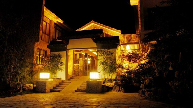 Una entrada luminosa a un edificio con un camino de piedra que conduce a unas escaleras.