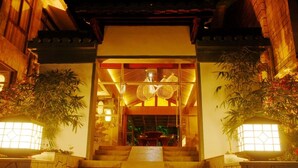 Una entrada tradicional al estilo japonés con una escalera de piedra que conduce a una puerta de madera.