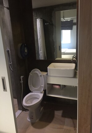 A small bathroom with a toilet, a sink, and a mirror. - 09 Hostel (Chiang Mai)
