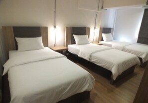 A hotel room with four single beds, each with a wooden headboard and white bedding. - 09 Hostel (Chiang Mai)