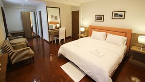 A hotel room with a large bed, a desk, a chair, and a small table. - 09 Hostel (Chiang Mai)