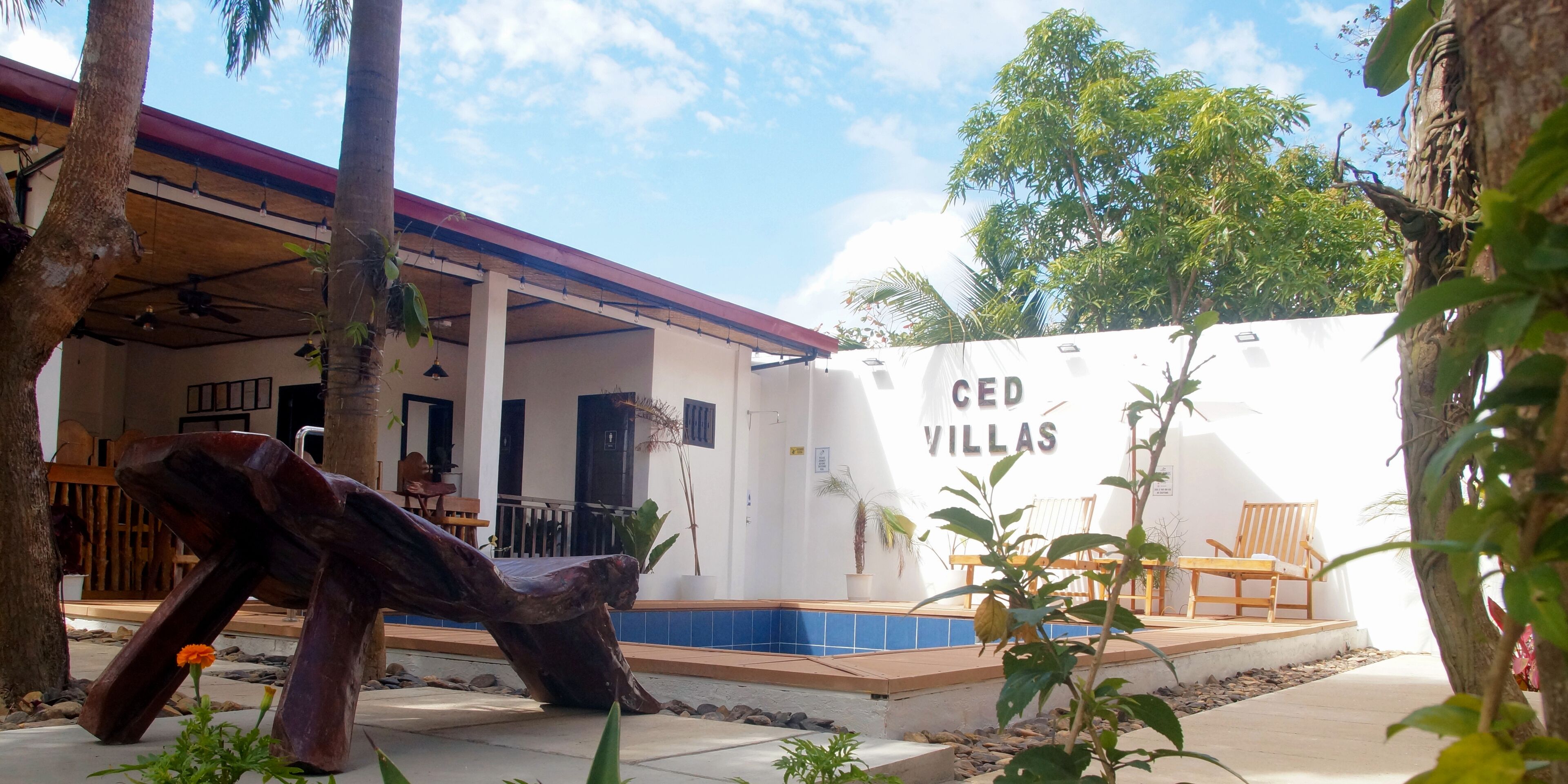 A building with a white exterior and a sign reading "CED VILLAS".