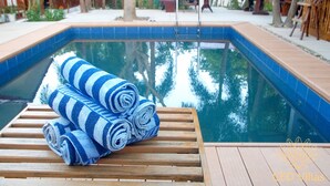 A pool with blue tiles and a wooden deck. - CED Villas (El Nido)