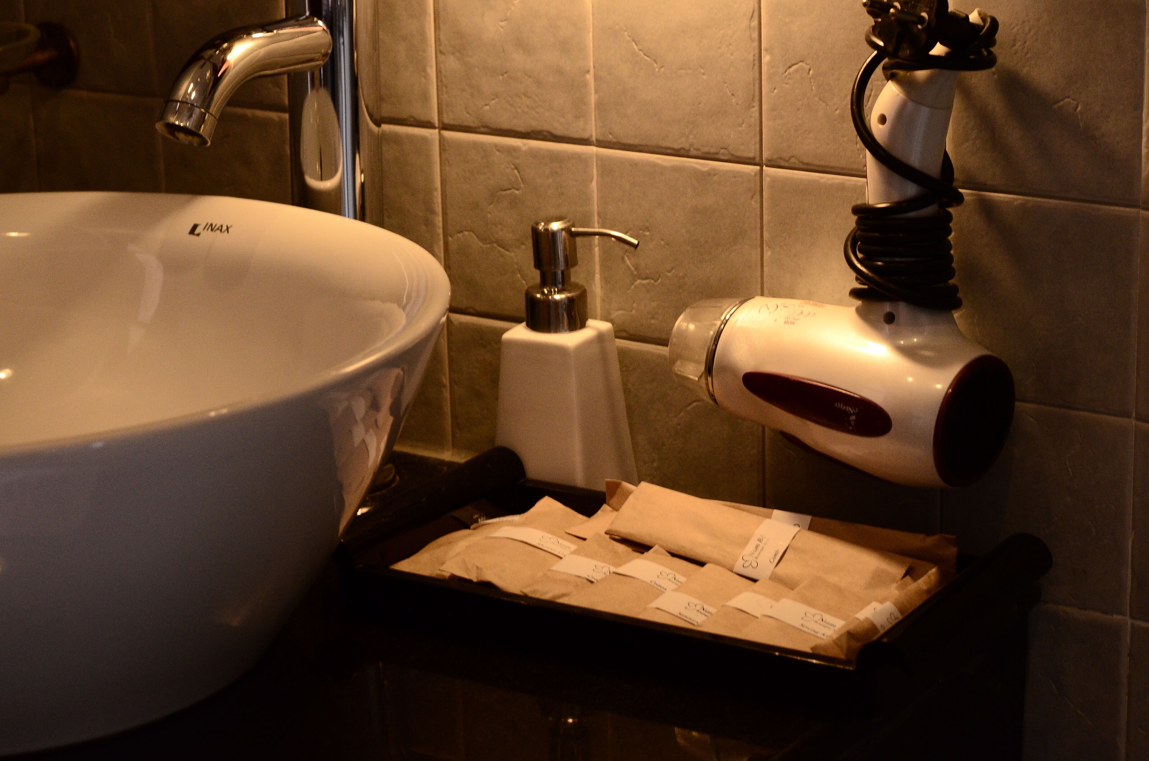 A bathroom sink with a faucet, a soap dispenser, and a towel warmer.