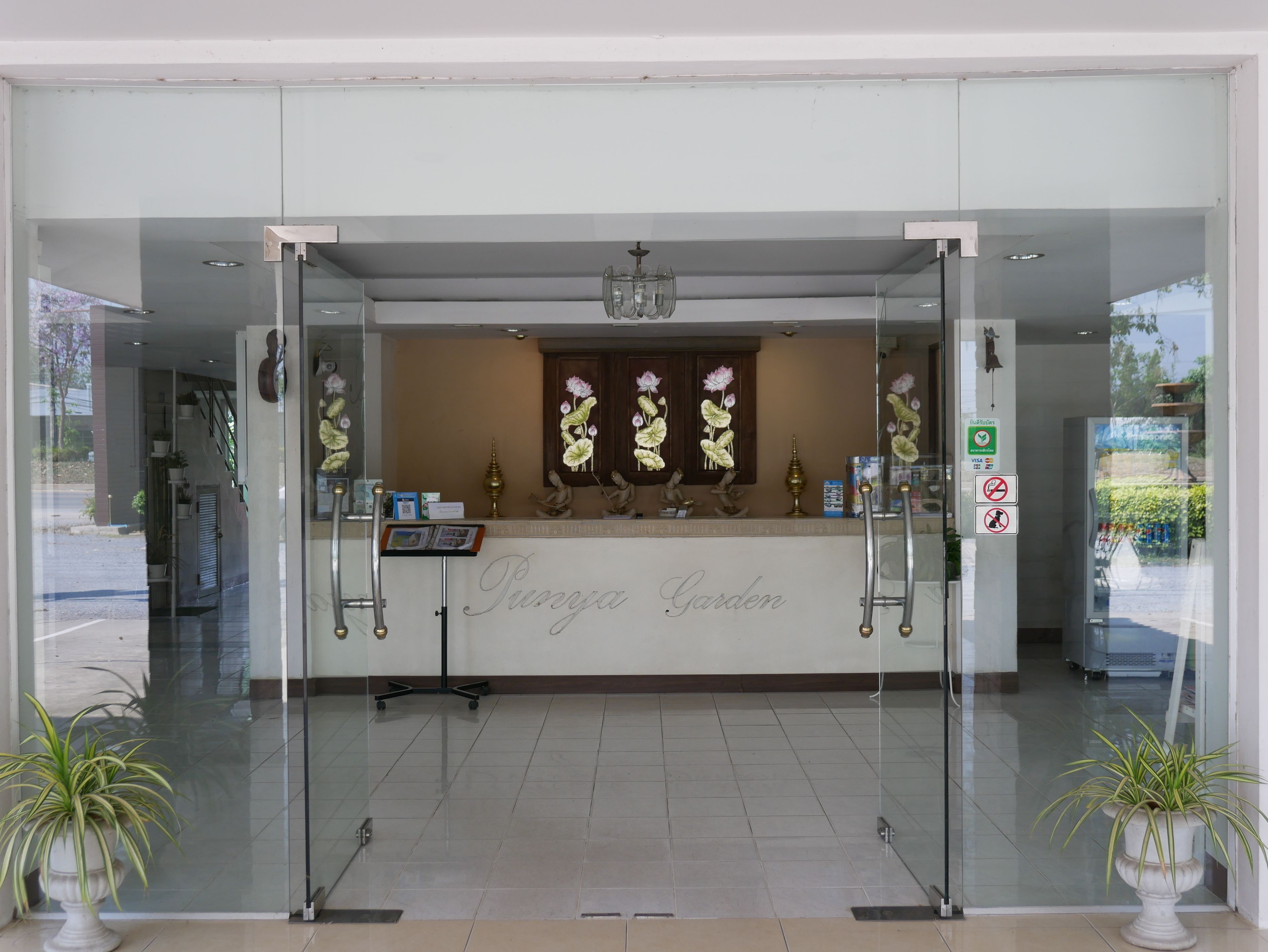 A reception area with a glass door, a sign reading "Puroja Garden," and a no-smoking sign.