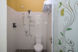 Un baño pequeño con inodoro, ducha y barra para toallas.