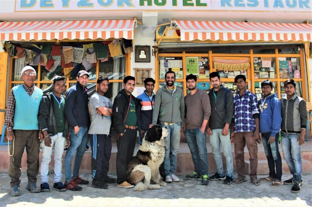 A group of people standing in front of a hotel named "DEY ZOR HOTEL RESTAURANT".