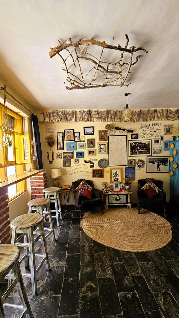 A cozy room with a rustic ceiling, a round woven rug, and a brick wall.