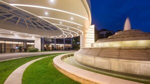 A modern building with a curved facade, a central fountain, and a well-maintained lawn. - Libre Resorts Huangshan (Huangshan)