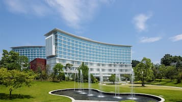 A modern building with a curved facade and a central fountain.