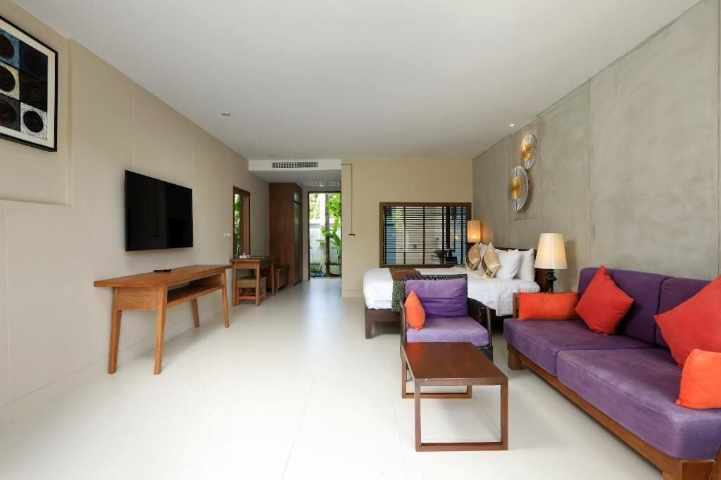 A modern living room with a sofa, a coffee table, a TV, and a dining area.