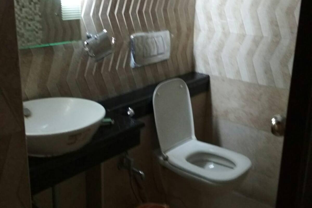 A bathroom with a white sink, a toilet, and a glass shower enclosure.