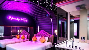 A hotel room with two beds, a neon sign, a bathtub, and a mirror. - Cupid Hotel (Ho Chi Minh City)