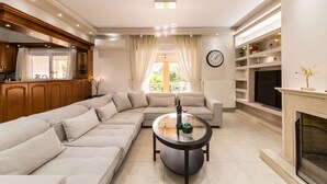 A modern living room with a sectional sofa, a round coffee table, and a fireplace.