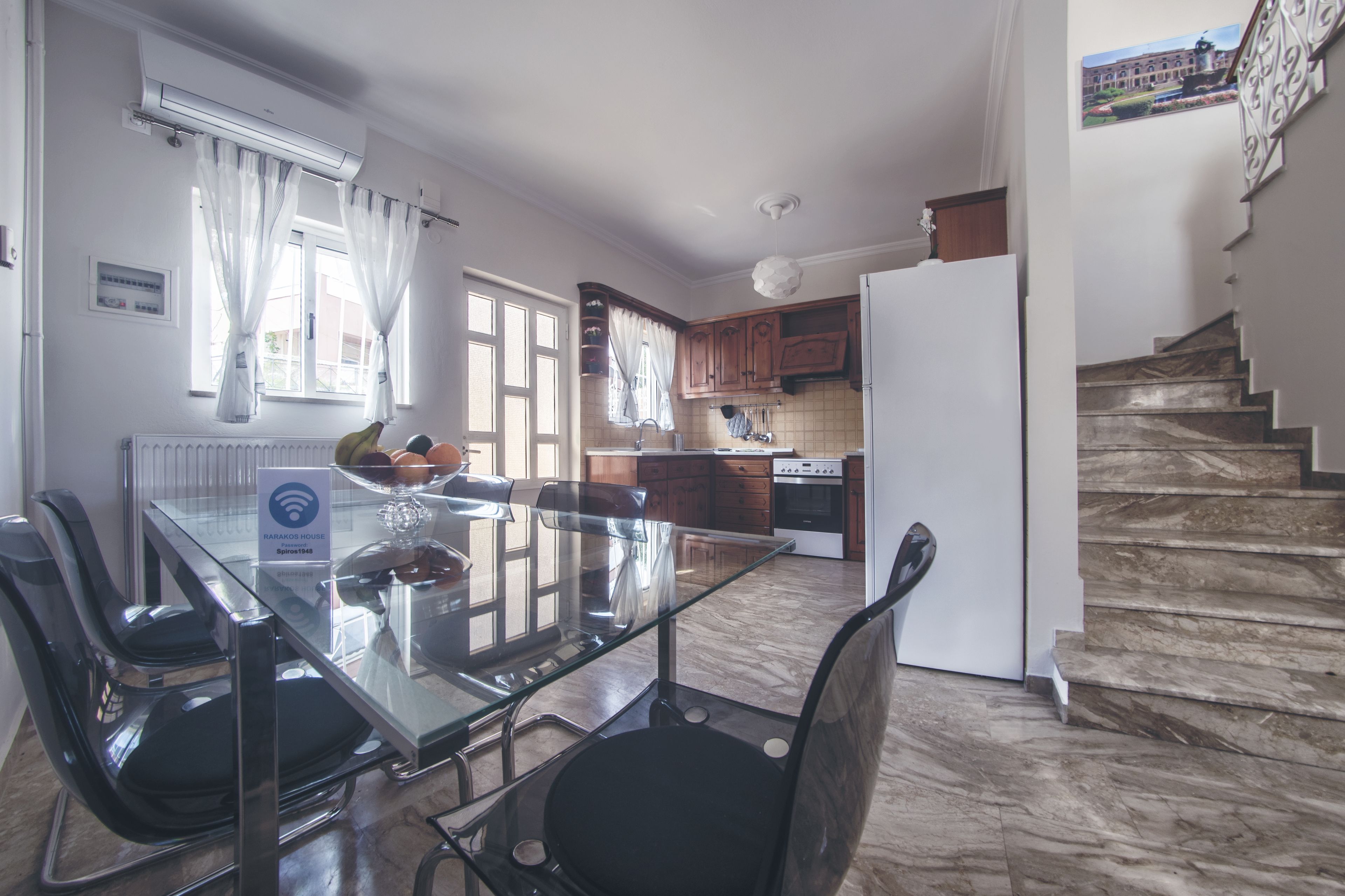 Een moderne keuken met een glazen eettafel, houten kastjes en een inbouwoven.