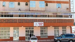 Un edificio de dos pisos con un letrero que indica el Hotel Shuhan.