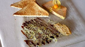 A plate with toasted bread, a piece of meat, sprouts, and a small orange. - Logis Le Relais Chenonceaux (Chenonceaux)