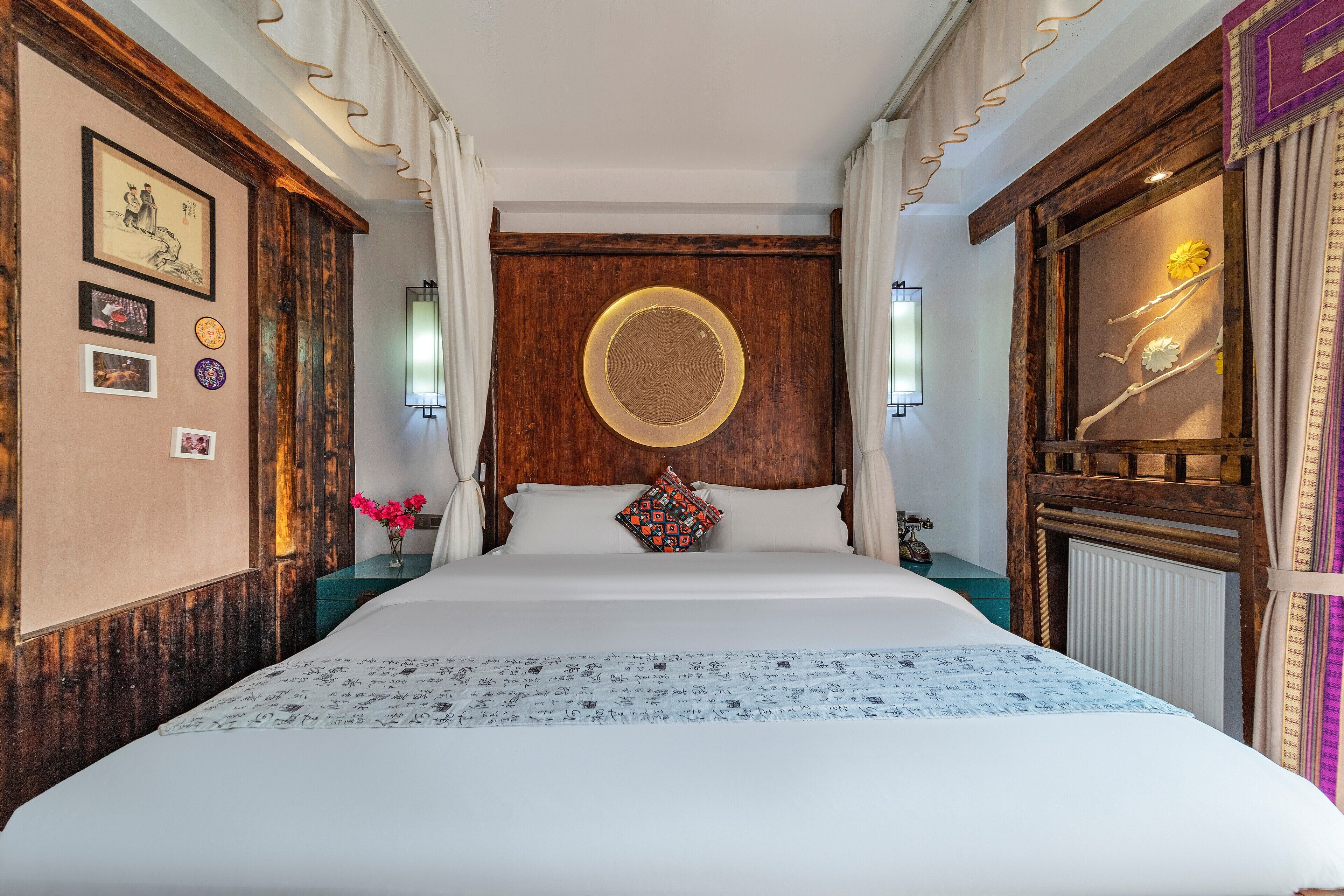 A neatly arranged bedroom with a large bed, wooden headboard, and a decorative wall panel.
