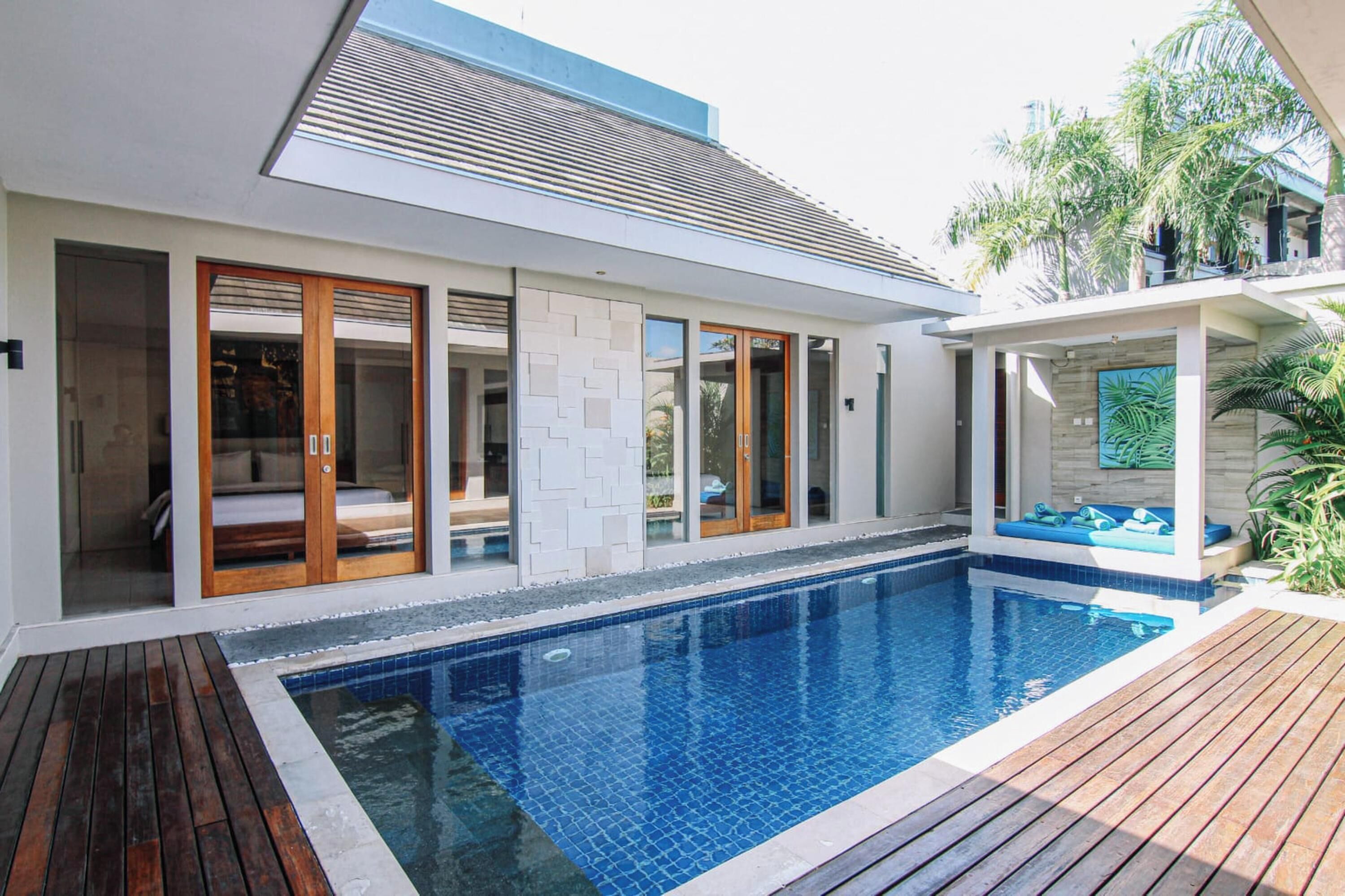 Ein modernes Haus mit Swimmingpool, Schiebegläsern und einer Terrassenanlage.