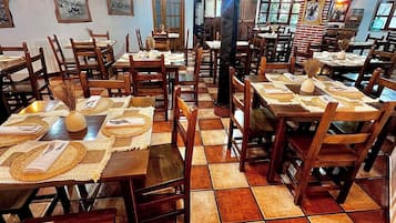 Un restaurante con mesas y sillas de madera, pisos de baldosas y vigas a la vista en el techo.