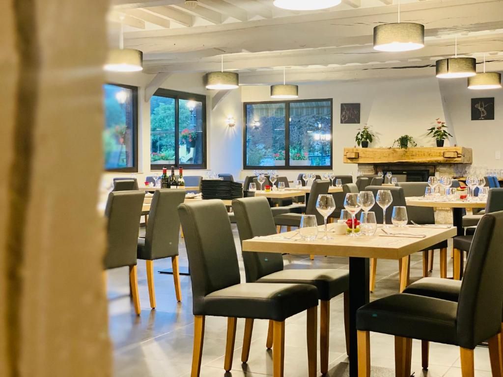 A restaurant interior with tables set for dining, chairs, and hanging pendant lights.