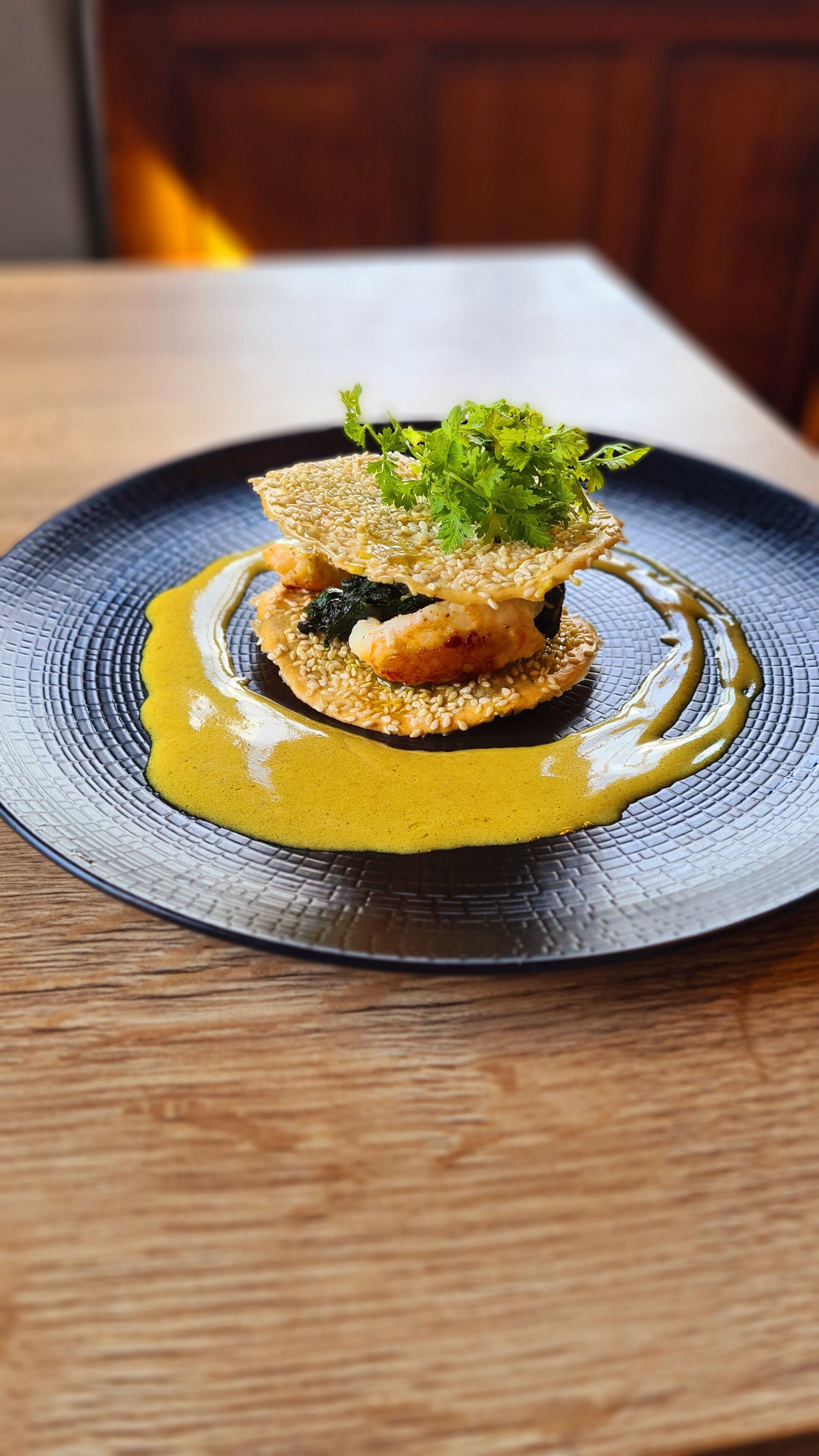 Un plato de comida con salsa y decoración sobre un plato con textura.